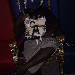 a man sitting on a throne holding a drink