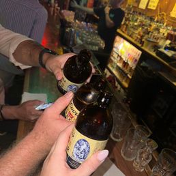 a man holding two bottles of beer