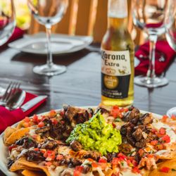 Captain Tony's - Nachos loaded with refried beans, cheese, jalapeños, Mexican Salsa, guacamole, and your choice of protein: chicken, beef,  or shrimp.