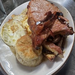 Pork chop brunch special. Biscuits and sausage, gravy, potatoes, and two eggs over medium.