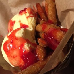 Funnel cake fries with vanilla ice cream and strawberry sauce. Funnel cake fries with vanilla ice cream and strawberry sauce.