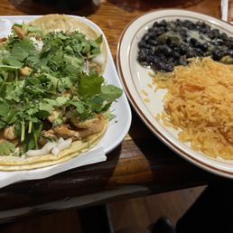 3 chicken tacos, side items black beans and rice