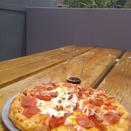 Three meat pizza with chocolate milk stout sampler and the Sandias in the background Three meat pizza with chocolate milk stout sampler and the Sandias in the background