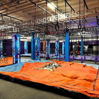 Altitude Trampoline Park Pueblo - A ninja-style obstacle course features hanging rings, ropes, and balance elements suspended over a large orange padded landin... - Trampoline Parks Near Me - Pueblo, Colorado Altitude Trampoline Park Pueblo - A ninja-style obstacle course features hanging rings, ropes, and balance elements suspended over a large orange padded landin... - Trampoline Parks Near Me - Pueblo, Colorado