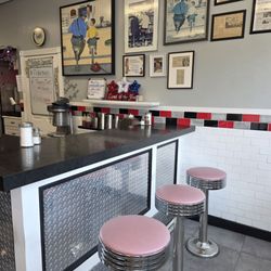 Counter seating looks updated. Rockwell art and news articles on wall. Look for specials boards.