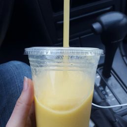 a hand holding a cup of juice a hand holding a cup of juice