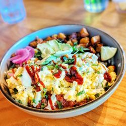 En Su Boca - Huevos Rancheros Mini quesadilla with black beans, cheesy eggs, salsa, lime crema, chile rojo, avocado, papas, pickled onions, & cilantro.