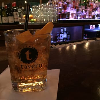 The Tavern - a tall glass with a drink on the bar - Lounges Near Me - Omaha, Nebraska The Tavern - a tall glass with a drink on the bar - Lounges Near Me - Omaha, Nebraska