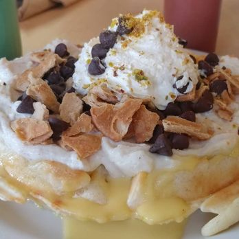 Sunny's - Cannoli waffle! It's filled with cannoli cream, covered in creme anglaise, whipped cream, pistachios, chocolate chips &crushed cannoli shell - Coffee & Tea Near Me - Denver, Colorado Sunny's - Cannoli waffle! It's filled with cannoli cream, covered in creme anglaise, whipped cream, pistachios, chocolate chips &crushed cannoli shell - Coffee & Tea Near Me - Denver, Colorado