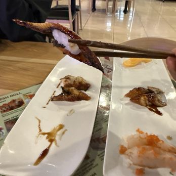 Sushi One Spot - I'm holding eel nigiri and the one with masago is raw shrimp - Sushi Bars Near Me - Corona, California Sushi One Spot - I'm holding eel nigiri and the one with masago is raw shrimp - Sushi Bars Near Me - Corona, California