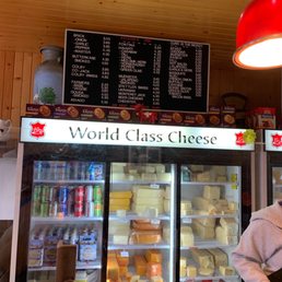 a man standing in front of a display of cheese
