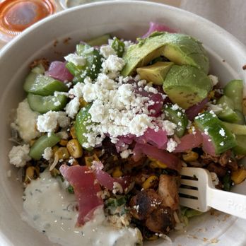 CAVA - Kale, corn, cucumbers, spicy chicken, feta, avocado, pickled onions and tz sauce - Salad Near Me - San Antonio, Texas