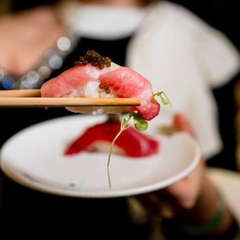 Mikado - a person holding a plate of sushi with chopsticks - Sushi Bars Near Me - New York, New York Mikado - a person holding a plate of sushi with chopsticks - Sushi Bars Near Me - New York, New York