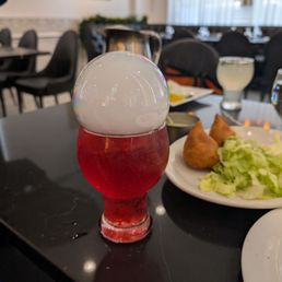 Strawberry dragon mocktail with minty lemon sparkler mocktail and half of an order of vegetarian samosas in the background. All were great.