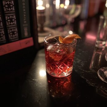 Pilcrow Cocktail Cellar - a glass with a drink and a slice of orange - Bars Near Me - Birmingham, Alabama