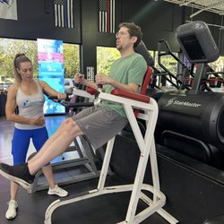 Elite Fitness - Diana Merhi guiding a client through leg raises at Elite Fitness.