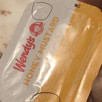 Wendy's - a hand holding a packet of honey mustard - Fast Food Near Me - Austin, Texas Wendy's - a hand holding a packet of honey mustard - Fast Food Near Me - Austin, Texas