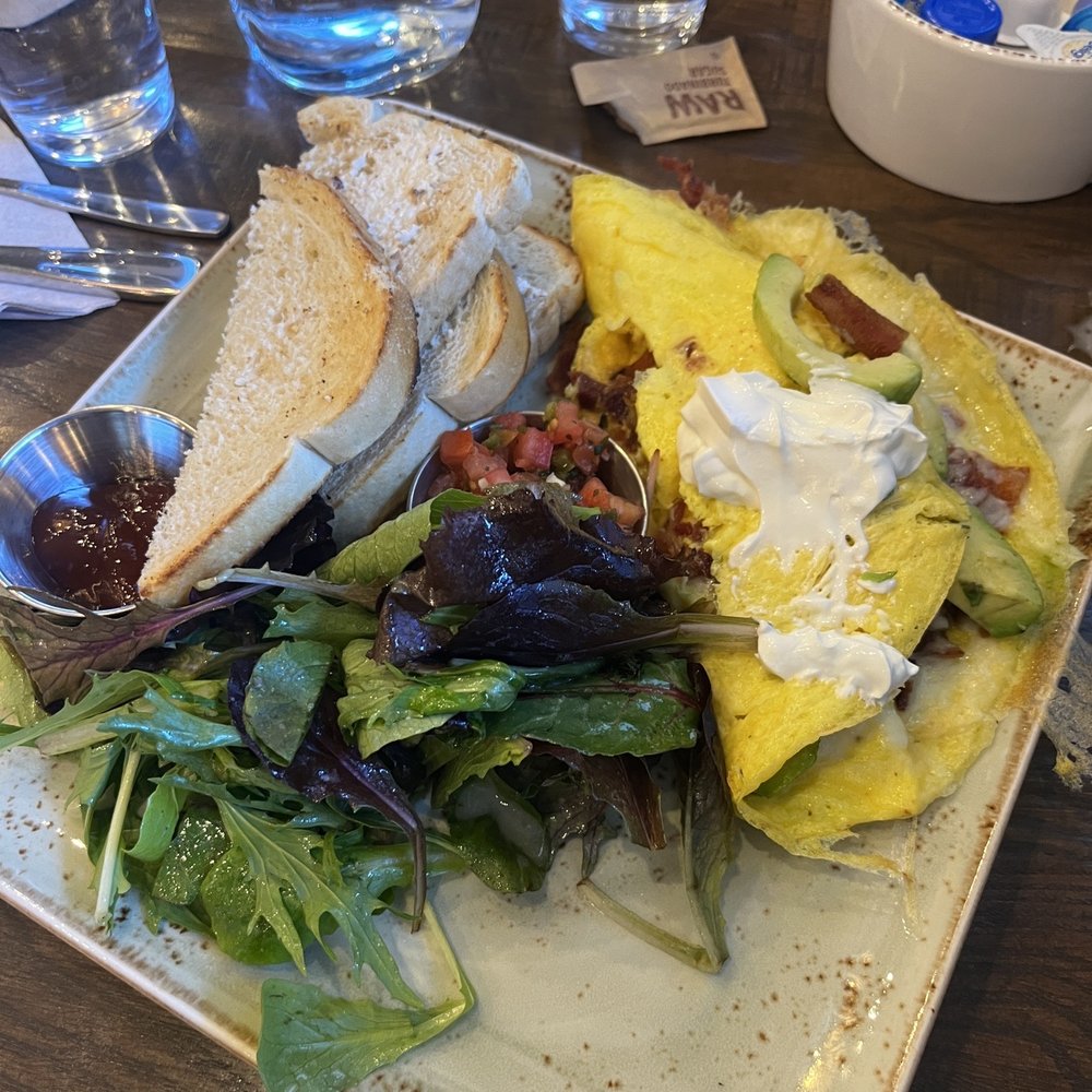 My bacon, avacado omelet with the menu serving of greens and toast