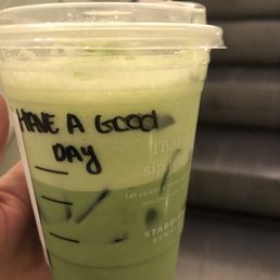 a hand holding a cup of green tea a hand holding a cup of green tea