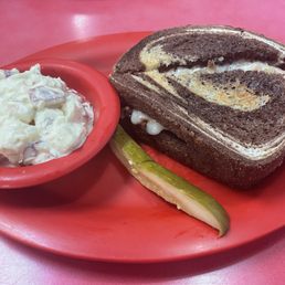 Grilled Turkey Reuben with a side of potato salad and a pickle for $12.99