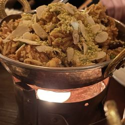 Ashoka - Chicken Biryani: Gebratener Basmati-Safran-Reis mit Hähnchenbrustfilet, Erbsen, Cashewnüssen, Rosinen, Mandeln und Pistazien.