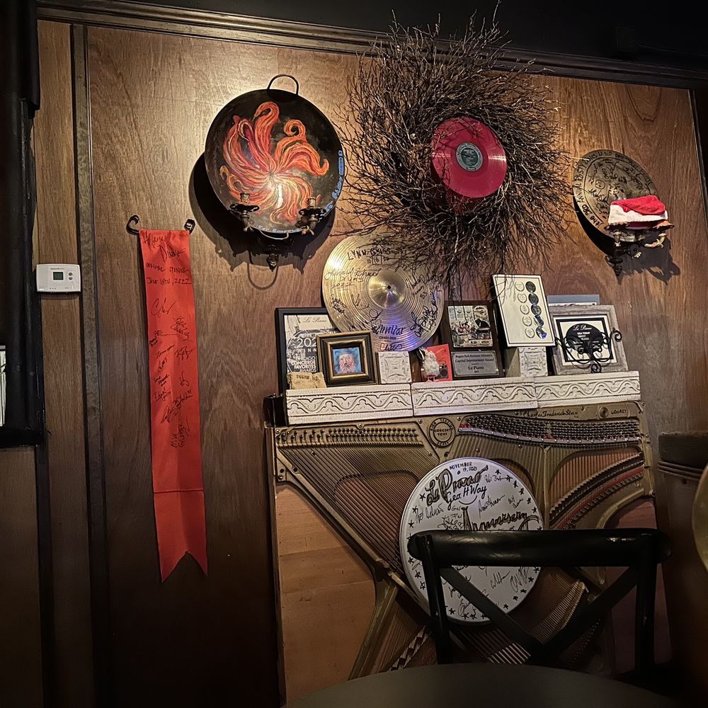 Le Piano - a room with a table, chair, clock, and pictures on the wall - Jazz & Blues Near Me - Chicago, Illinois Le Piano - a room with a table, chair, clock, and pictures on the wall - Jazz & Blues Near Me - Chicago, Illinois