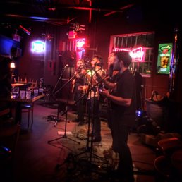 ows a band performing in a dimly lit room