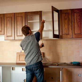 Master Builders Renovation - a man fixing cabinets in a kitchen - General Contractors Near Me - Malden, Massachusetts