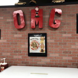 a brick wall with a sign that says oh gyro a brick wall with a sign that says oh gyro