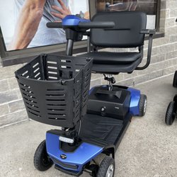 Houle Healthcare - Amylior gs100 scooter in blue colour posed infront of a window of someone getting a massage
