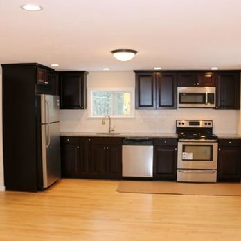 CS Mass Construction - a kitchen with black cabinets and stainless steel appliances - General Contractors Near Me - Hingham, Massachusetts CS Mass Construction - a kitchen with black cabinets and stainless steel appliances - General Contractors Near Me - Hingham, Massachusetts