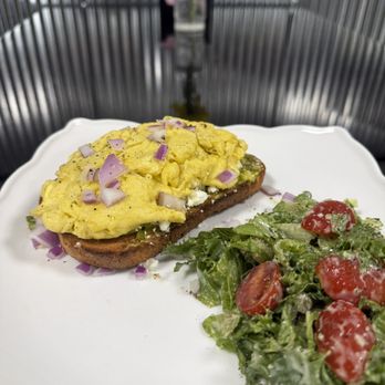 Sunrise Cafe - Avocado toast on toasted multigrain bread with crumbled feta, hot honey, onions, and flaky sea salt. W/ two eggs any style and mixed greens - American Near Me - Kokomo, Indiana Sunrise Cafe - Avocado toast on toasted multigrain bread with crumbled feta, hot honey, onions, and flaky sea salt. W/ two eggs any style and mixed greens - American Near Me - Kokomo, Indiana