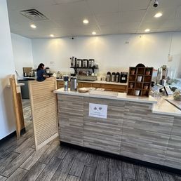 a coffee shop counter with a person in the background a coffee shop counter with a person in the background