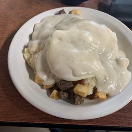 Big country biscuit with potatoes and eggs before that gravy was dropped on it. Big country biscuit with potatoes and eggs before that gravy was dropped on it.