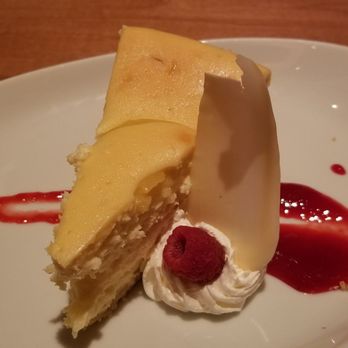 Woodfire Grille - Lemon cheesecake. Served with raspberry sauce and a shave of white chocolate. - Steakhouses Near Me - Mulvane, Kansas