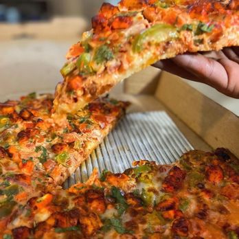 Can Am Pizza - a hand holding a slice of pizza - Pizza Near Me - Redmond, Washington Can Am Pizza - a hand holding a slice of pizza - Pizza Near Me - Redmond, Washington