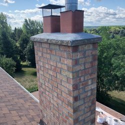 Brick chimney with new concrete rain pan and chimney cleaning done on it.