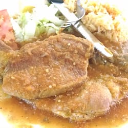 Pork chops in red hot sauce with rice and beans. Just awesome!
