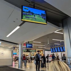 Concourse B - LIV Golf Houston 2024 Round 1 broadcast live on TV screens inside Concourse B. Gate B19.