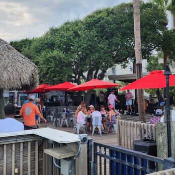 Tiki Hut - a group of people sitting at tables under umbrellas - Tiki Bars Near Me - Hilton Head Island, South Carolina Tiki Hut - a group of people sitting at tables under umbrellas - Tiki Bars Near Me - Hilton Head Island, South Carolina