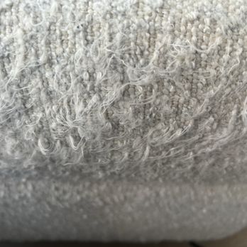 Beeclean - The fabric completely ruined and ripped out - The image depicts a close-up view of a fabric material with visible tearing and fraying of fibers. The fibers are unevenly damaged, with some strands sticking out, indicating wear or damage. The fabric appears to be textured, with a mix of tightly woven and loose fibers, possibly from upholstery or carpet material. - Carpet Cleaning Near Me