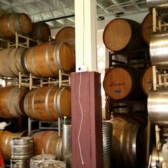 Lusu Cellars - a woman standing in front of barrels - Wineries Near Me - Berkeley, California