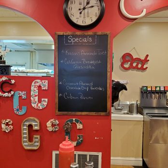 Carmela's on the Extension - a red wall with a chalkboard and a clock - Breakfast & Brunch Near Me - Middletown, Connecticut Carmela's on the Extension - a red wall with a chalkboard and a clock - Breakfast & Brunch Near Me - Middletown, Connecticut