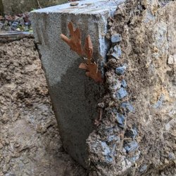 Ellis Masonry - Slopped some sakcrete on top of failed footing on ground. Said he would remove old footing and install new 8" thick below frost line.