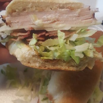 Tailgate Subs - a person holding a sandwich in a styrofoam container - Delis Near Me - Buffalo, New York