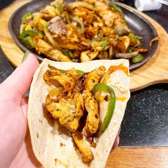 El Rodeo - a hand holding a taco with chicken and peppers - Mexican Near Me - Maple Grove, Minnesota