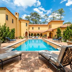 KMc Media - Real estate photography of residential home's exterior back landscaped with pool and sitting areas.