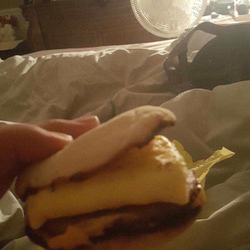 McDonald's - a person holding a sandwich in front of a television - Burgers Near Me - Blaine, Minnesota