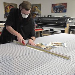 Nocerino Editions - Printing Tech cutting a small edition of prints down to size