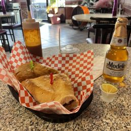 a sandwich and a beer on a table a sandwich and a beer on a table